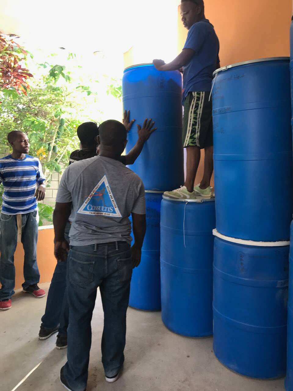 Volunteers loading blue relief barrels destined for Haiti