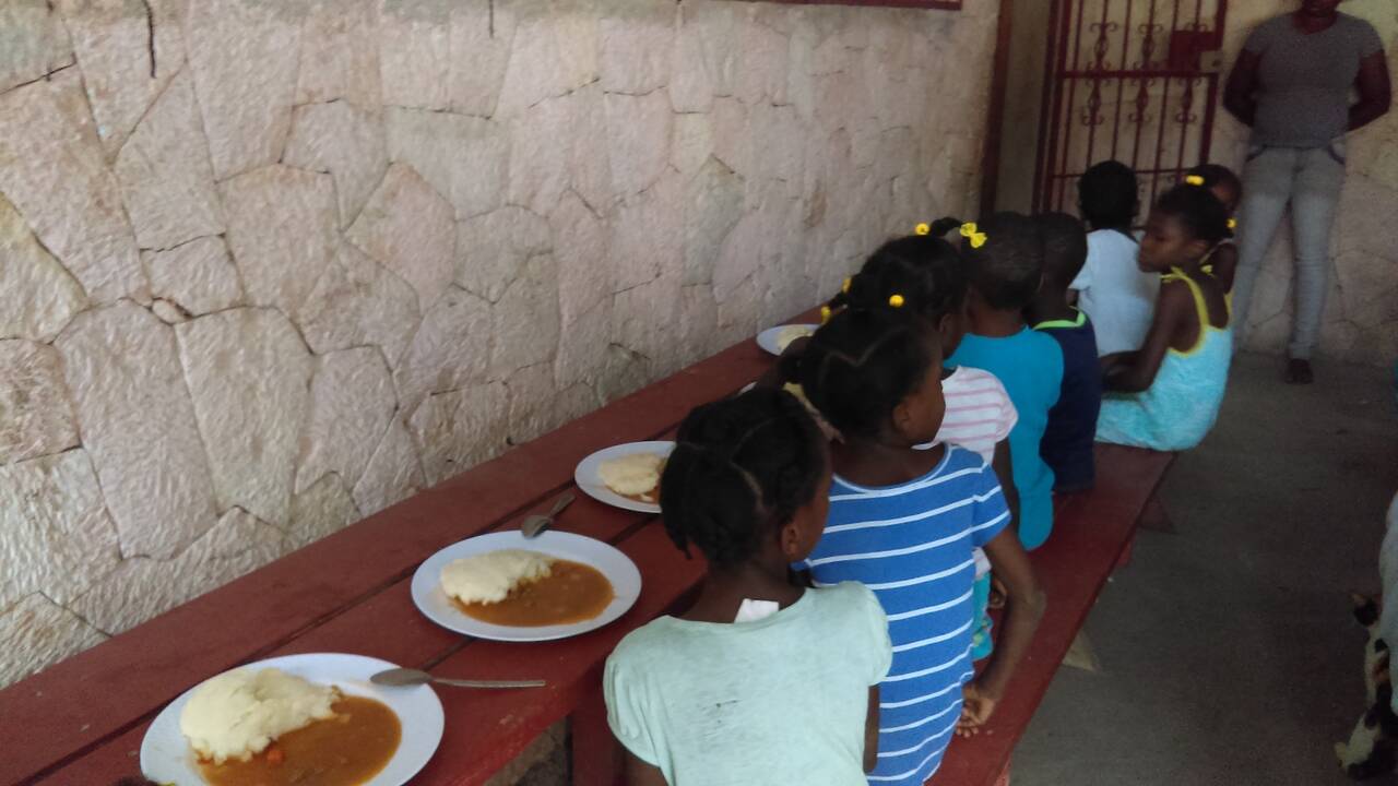 Children lining up for plates of food at the feeding program