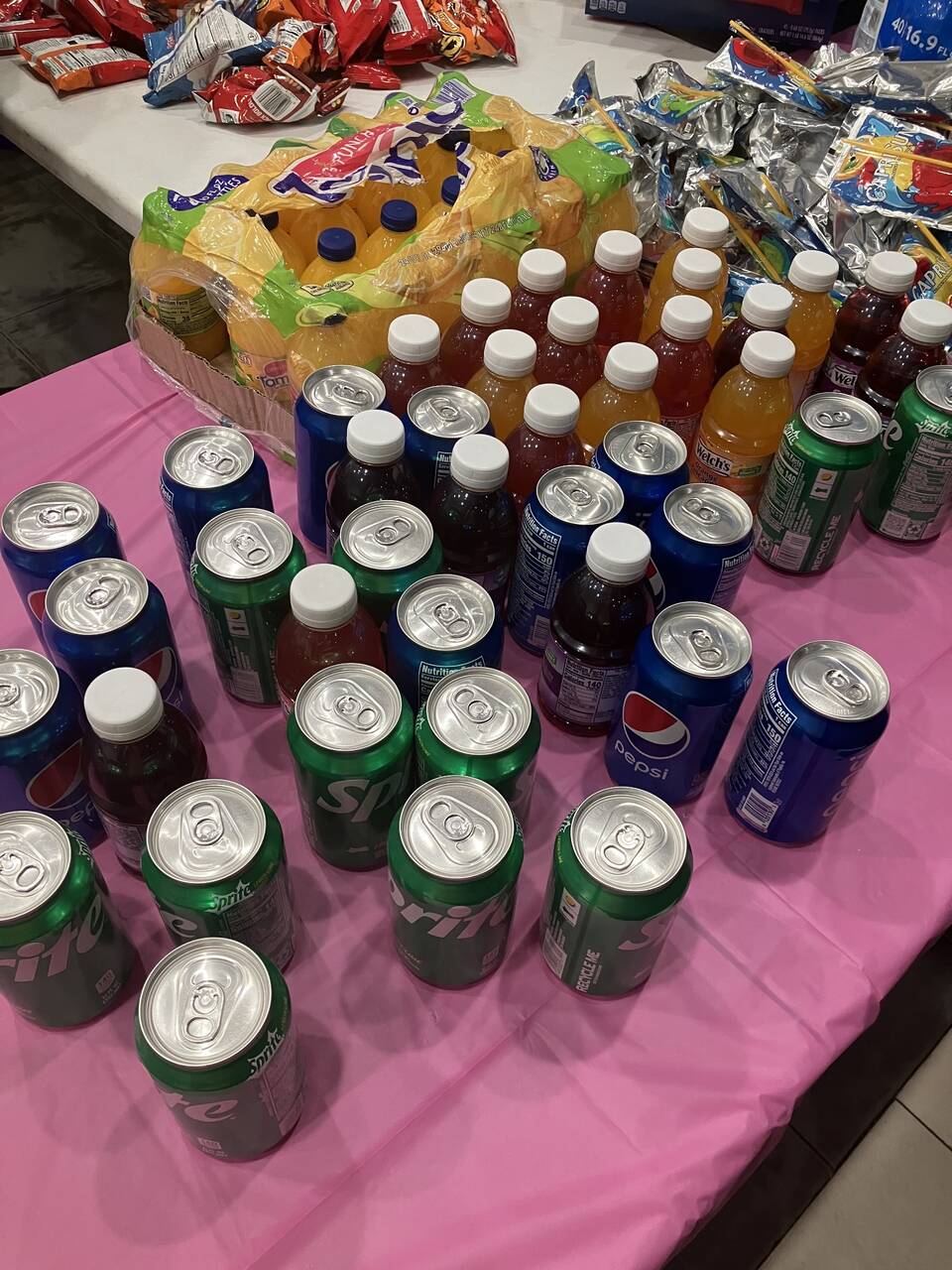 Bottled juices, soda cans, and Capri Sun pouches set out for the meal